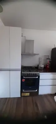 a kitchen with a stove and white cabinets at Departamento con salida a la peatonal! in Villa Carlos Paz