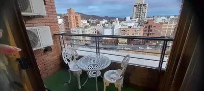 a balcony with two chairs and a view of a city at Departamento con salida a la peatonal! in Villa Carlos Paz