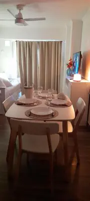 a table with wine glasses on it in a living room at Departamento con salida a la peatonal! in Villa Carlos Paz