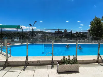 a large blue swimming pool with people in it at Departamento con salida a la peatonal! in Villa Carlos Paz