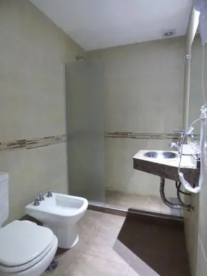 a bathroom with a toilet and a sink at Hotel Pinar del Lago in Villa Carlos Paz