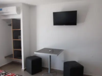a room with a table and a tv on a wall at Hotel Pinar del Lago in Villa Carlos Paz