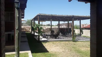 a patio with tables and chairs under a pergola at Rio De Arena in Nono
