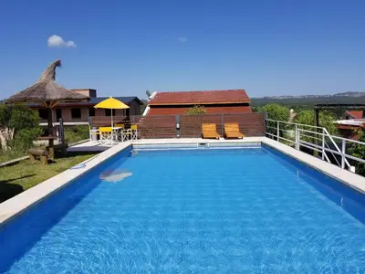 a swimming pool with blue water in front of a house at Rio De Arena in Nono