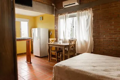 a kitchen with a table and a refrigerator in a room at Rio De Arena in Nono