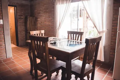 a wooden table with four chairs and a window at Rio De Arena in Nono