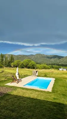 a swimming pool in the middle of a field at Mutterstern Chalet Boutique in Villa General Belgrano