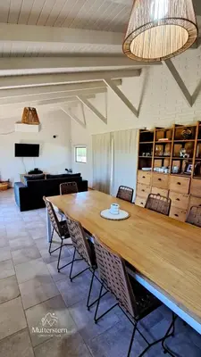 a dining room with a large wooden table and chairs at Mutterstern Chalet Boutique in Villa General Belgrano