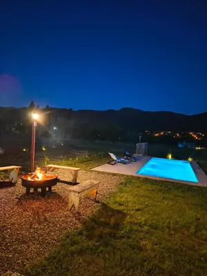 a backyard with a swimming pool at night at Mutterstern Chalet Boutique in Villa General Belgrano