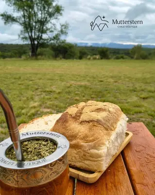 a loaf of bread on a table with a can of mustard at Mutterstern Chalet Boutique in Villa General Belgrano