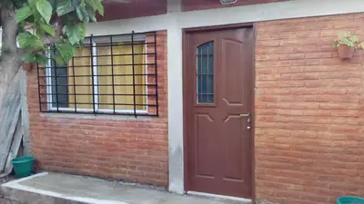 a red door on the side of a brick building at Fernando in Villa Independencia