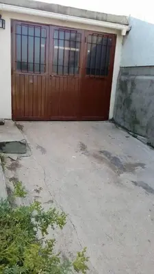 a garage with a wooden door in front of a house at Fernando in Villa Independencia