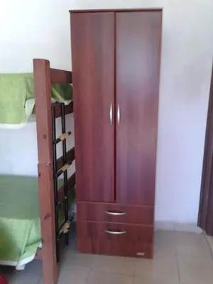 a wooden cabinet in a room next to a bed at Fernando in Villa Independencia