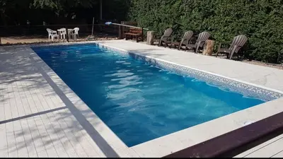 a swimming pool with chairs and blue water at Colores de Traslasierra in Mina Clavero