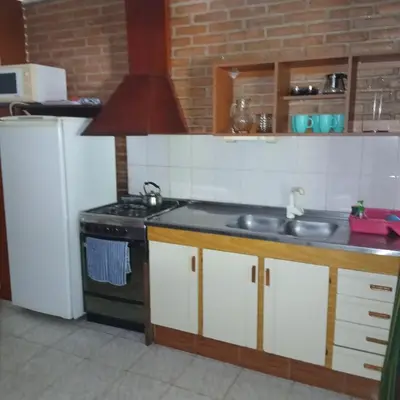 a kitchen with a sink and a stove at Colores de Traslasierra in Mina Clavero