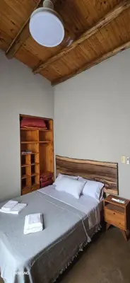 a bedroom with a large bed and a wooden ceiling at Ilusión tunkelen in Merlo