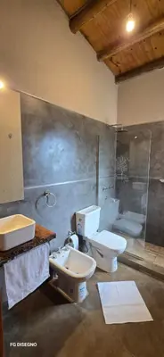 a bathroom with two toilets and a sink at Ilusión tunkelen in Merlo