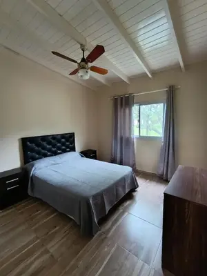 a bedroom with a bed and a ceiling fan at Cabañas EL VALLE in Villa Rumipal