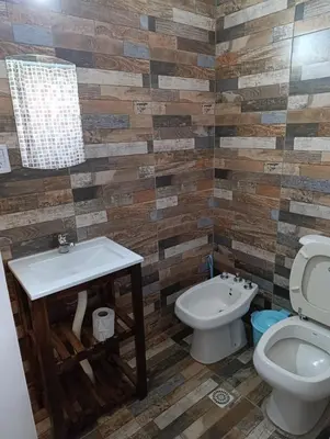 a bathroom with a toilet and a sink at Cabañas EL VALLE in Villa Rumipal