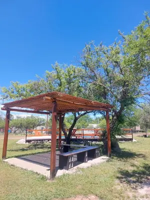 a picnic shelter in a park with a tree at Cabañas EL VALLE in Villa Rumipal