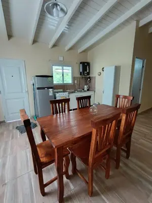 a wooden dining table and chairs in a kitchen at Cabañas EL VALLE in Villa Rumipal