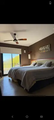 a bedroom with a large bed with a ceiling fan at Villa Lourdes in La Estancia