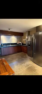 a kitchen with a stainless steel refrigerator and a wooden table at Villa Lourdes in La Estancia