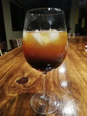 a glass of drink sitting on a wooden table at Villa Lourdes in La Estancia