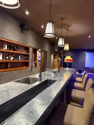 a bar in a restaurant with a sink and chairs at Villa Lourdes in La Estancia