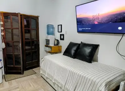 a bedroom with a bed with a large tv on the wall at Tu Escapada in Santa María