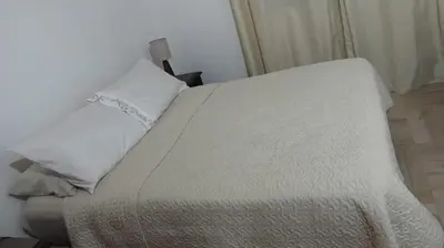 a bed with white sheets and pillows in a room at Tu Escapada in Santa María