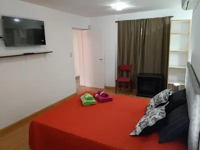 a bedroom with a red bed with two slippers on it at Deptos Charito in Cordoba