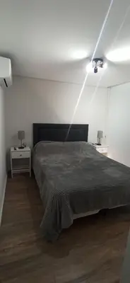 a bedroom with a large bed and a ceiling at Hermoso Departamento en Opera Plaza al lado de Quality Espacios in Cordoba