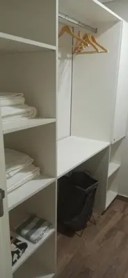 a white walk in closet with white shelves at Hermoso Departamento en Opera Plaza al lado de Quality Espacios in Cordoba