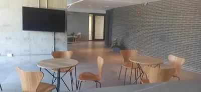 a room with two tables and chairs and a flat screen tv at Hermoso Departamento en Opera Plaza al lado de Quality Espacios in Cordoba