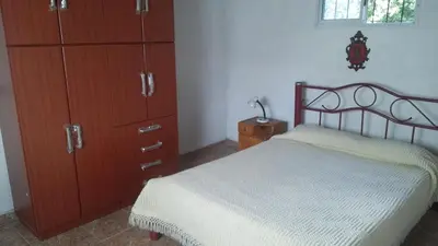 a bedroom with a bed and wooden cabinets at Departamentos Paz Serrana in Villa Cura Brochero