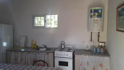 a kitchen with a white stove and a sink at Departamentos Paz Serrana in Villa Cura Brochero