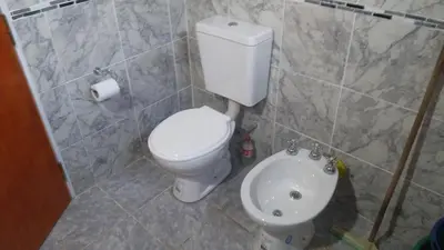 a bathroom with a white toilet and a sink at Departamentos Paz Serrana in Villa Cura Brochero