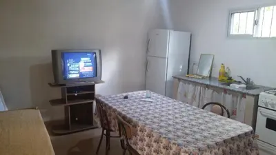 a kitchen with a table and a tv and a table and chairs at Departamentos Paz Serrana in Villa Cura Brochero