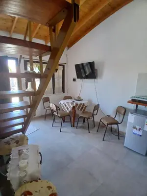 a living room with a table and chairs and a tv at Apart La Jose in Río Cuarto