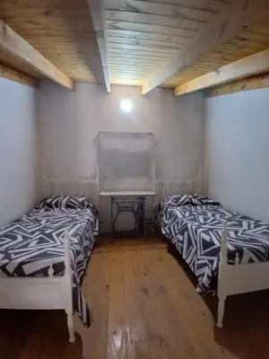 two beds in a room with a piano at Apart La Jose in Río Cuarto