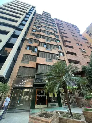 a tall building with a palm tree in front of it at Nueva Córdoba in Cordoba