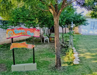 a sign in a yard next to a tree at María Reina De La Paz in Villa Cura Brochero