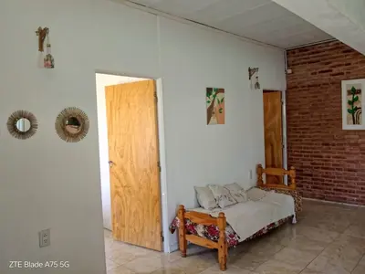 a bedroom with a bed and a wooden door at María Reina De La Paz in Villa Cura Brochero