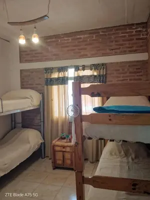 a room with three bunk beds and a lamp at María Reina De La Paz in Villa Cura Brochero