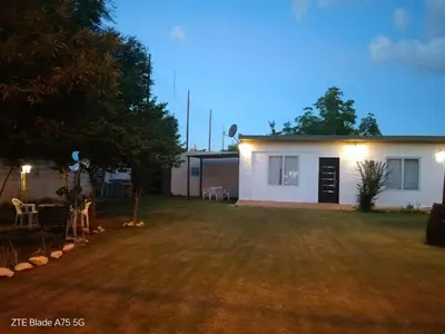 a backyard at night with a white house at María Reina De La Paz in Villa Cura Brochero