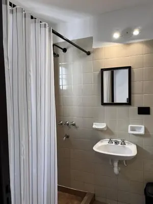 a bathroom with a sink and a shower curtain at Monoambiente moderno en Nueva Córdoba Gray Urban in Cordoba