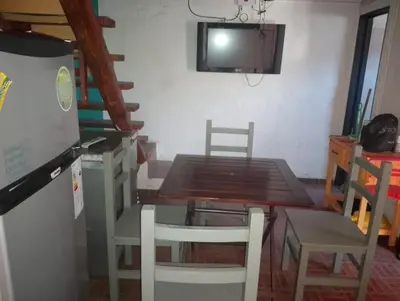 a dining room with a table and chairs and a tv at Departamento mina clavero in Mina Clavero