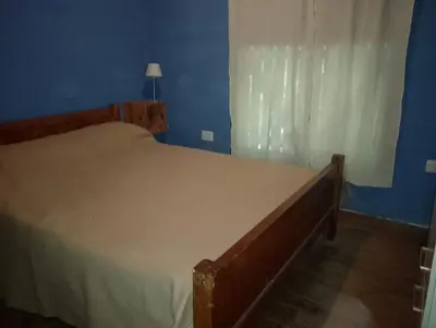 a bedroom with a large bed with a white curtain at Departamento mina clavero in Mina Clavero