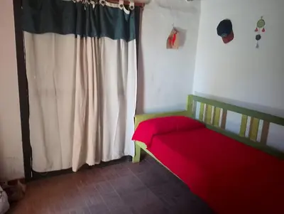 a bedroom with a red bed and a window at Departamento mina clavero in Mina Clavero